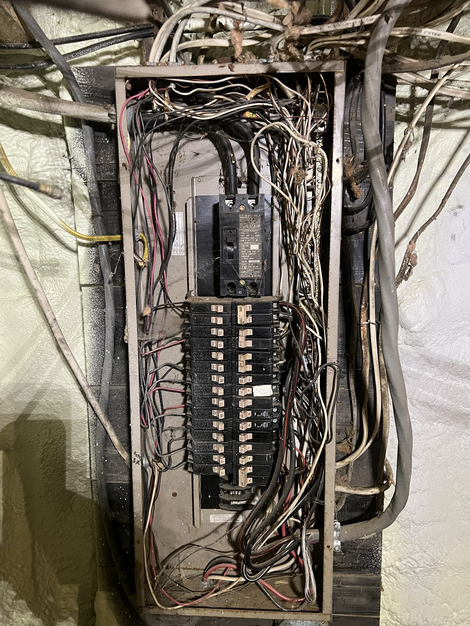 Tangled, overloaded electrical panel wiring before rework